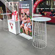 White wire cocktail tables displayed inside the Sydney Swans AFLW event space with branded promotional displays and lounge seating