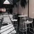 A white table and chairs in a courtyard, available for White Stool Hire.