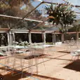 A white tent with tables and chairs in it, available for White Stool Hire.
