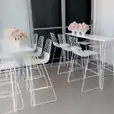 A set of white bar stools with flowers on them available for White Arrow Stool Hire.
