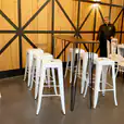 A white table and chairs are set up in a room for hire.