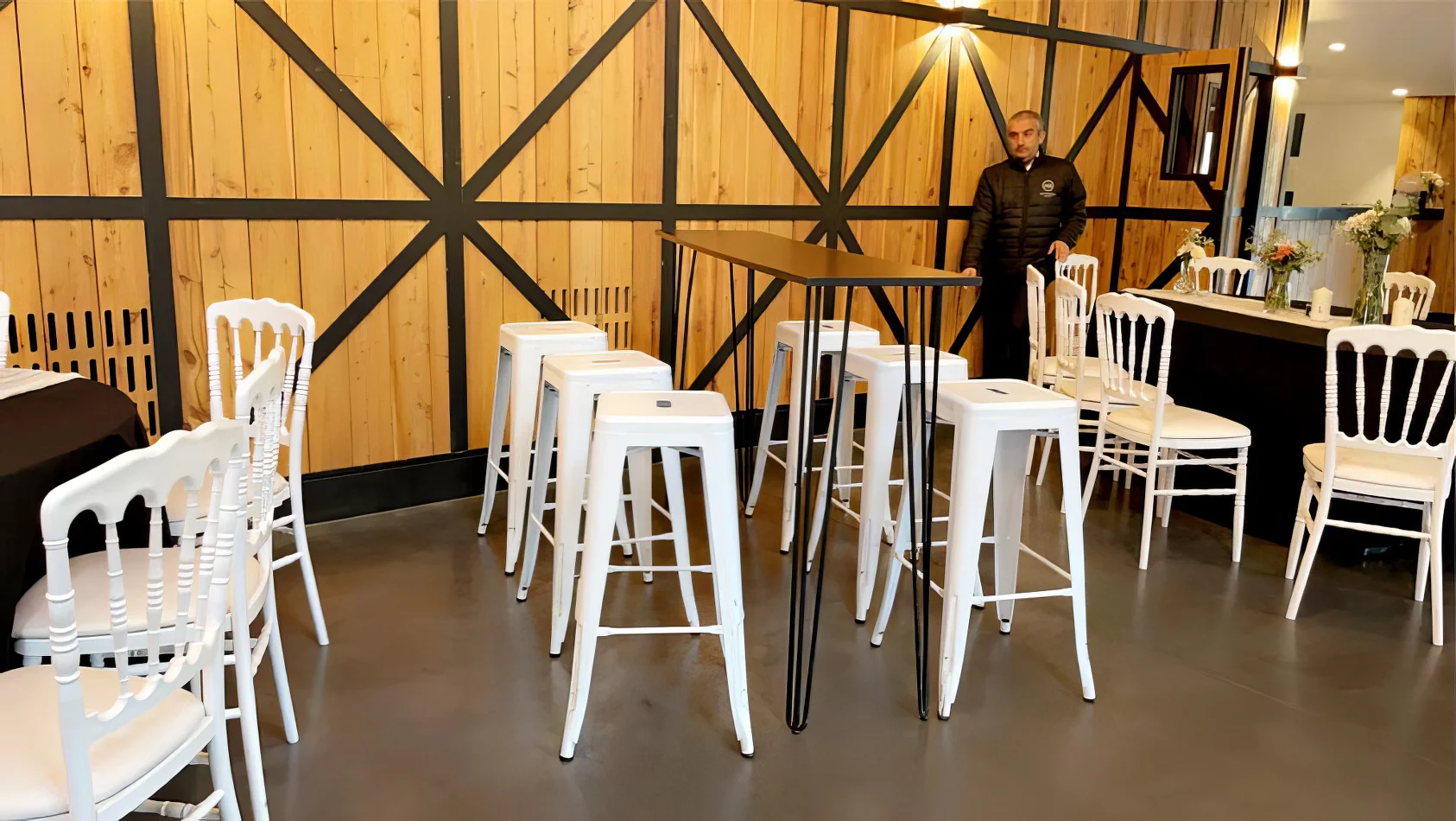 A white table and chairs are set up in a room for hire.