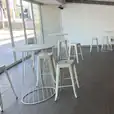 White Tolix stools in a room with large windows.
