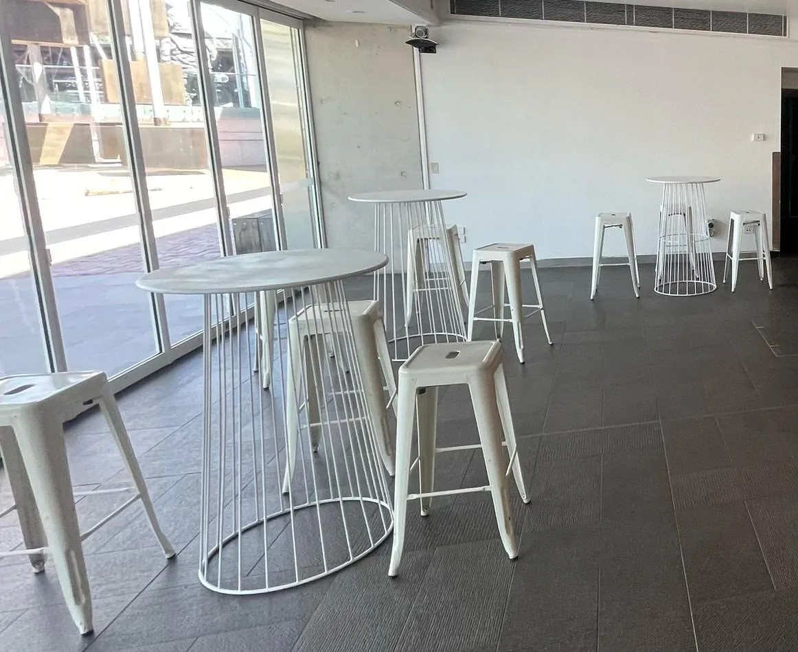 White Tolix stools in a room with large windows.