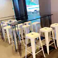 A row of white Tolix stools in an office.