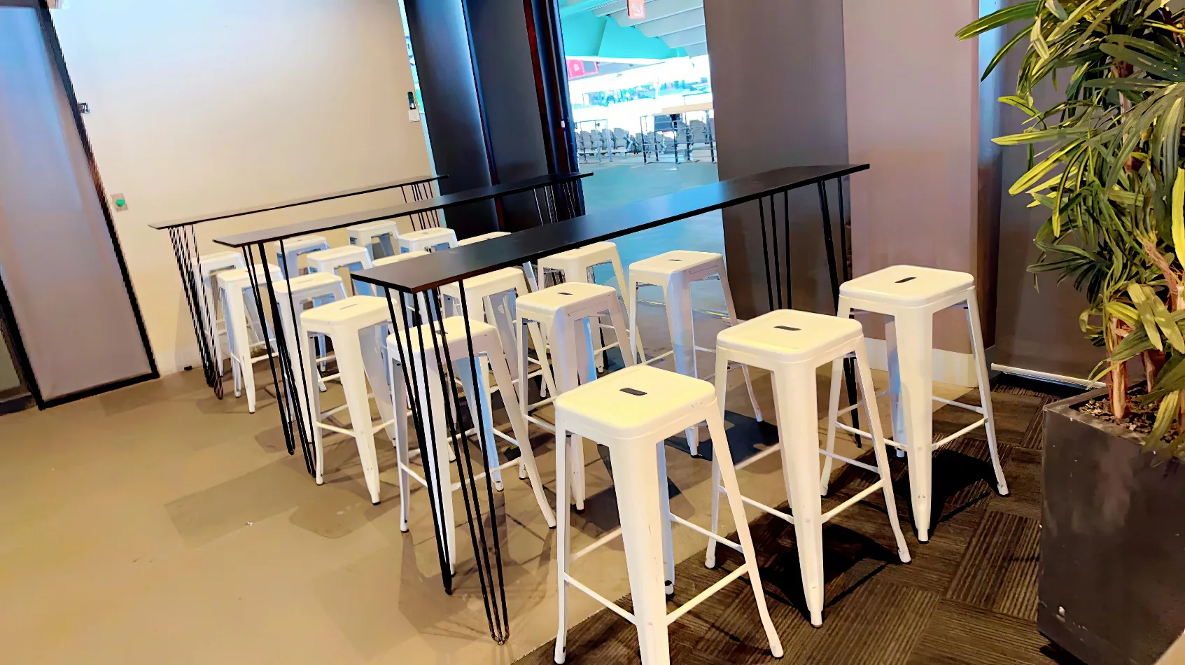 A row of white Tolix stools in an office.