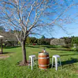 A beautiful outdoor setting with a wine barrel and some stools around it